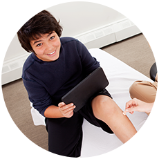 boy-on-treatment-table-with-tablet boy on a treatment table while using a tablet